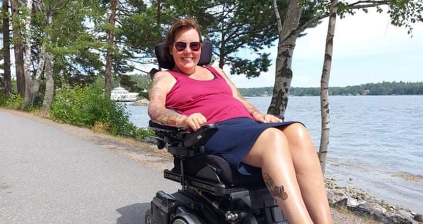 Mia Möllberg i sin rullstol i solen. Foto.
