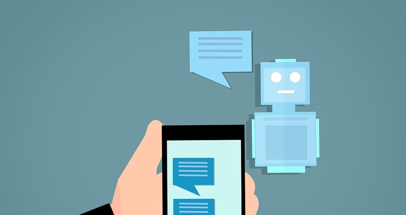 En hand som håller i en mobiltelefon och chattar med en robot som syns i bakgrunden. Illustration.