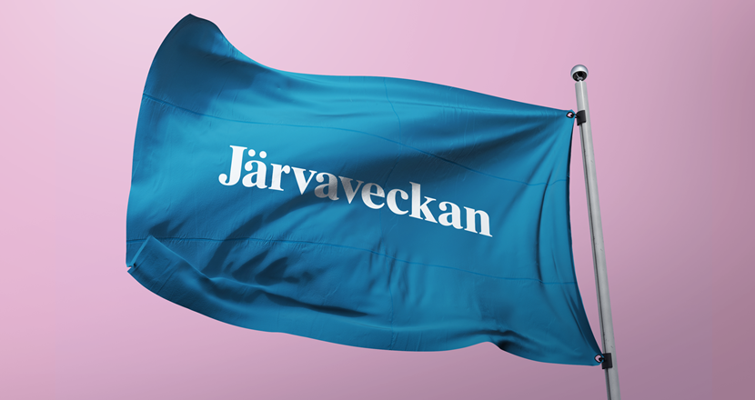Järvaveckans flagga, Järvaveckan som vit text på blå botten med en rosa bakgrund.