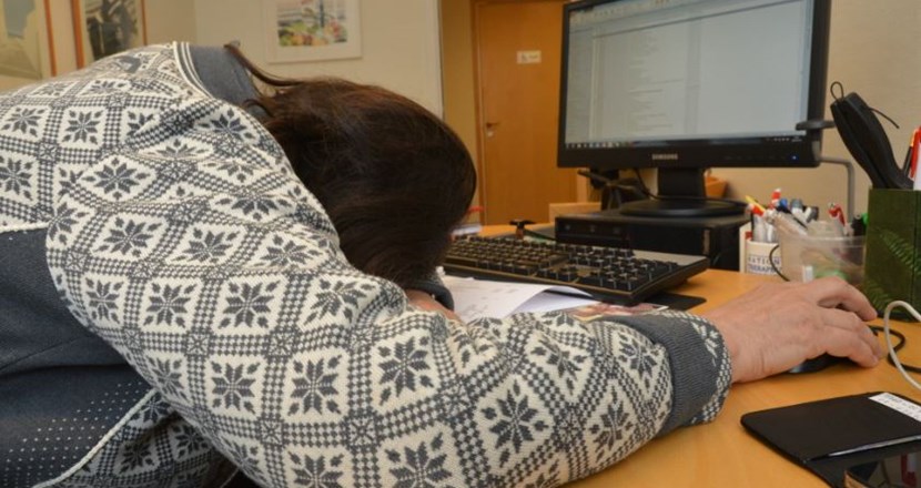 En person som sover över tangentbordet. Foto.