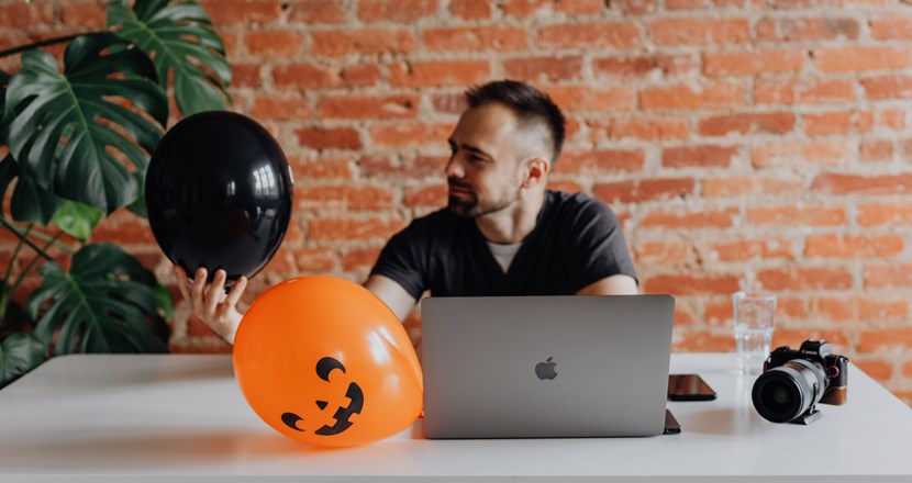 Man leker med ballonger framför dator