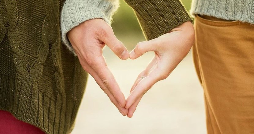 Ungt par som formar sina händer i form av ett hjärta