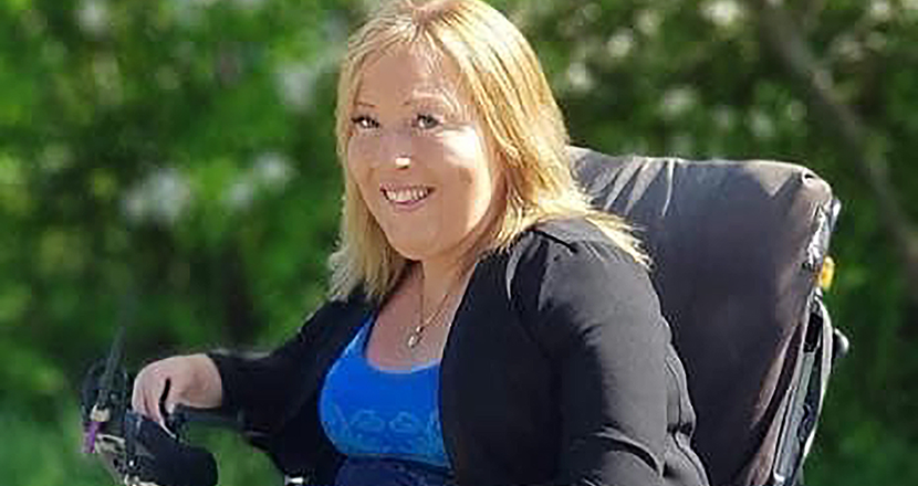 Maria Mattson mot en grönskande bakgrund. Foto.