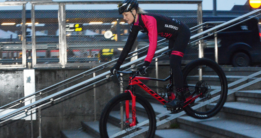 Camilla cyklar nerför en trappa. Foto.
