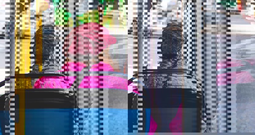 En kvinna som sitter i en buss som åker genom staden.