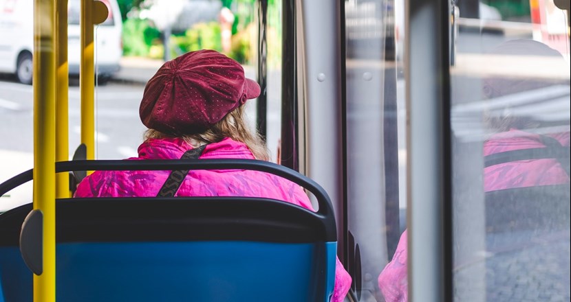 En kvinna som sitter i en buss som åker genom staden.