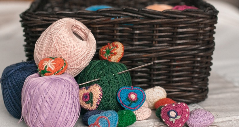 Korg med garnnystan och virkade hjärtan framför.