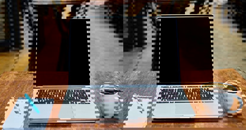 Ett block, en dator och en kopp kaffe. Foto.