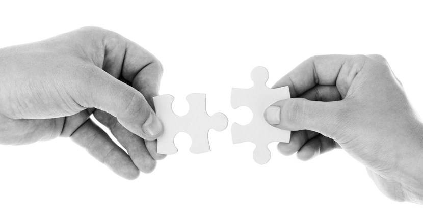 Vi söker kontaktpersoner - en svartvit bild med två händer och pusselbitar. Bild: pixabay.com.