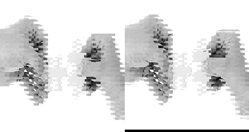 Vi söker kontaktpersoner - en svartvit bild med två händer och pusselbitar. Bild: pixabay.com.