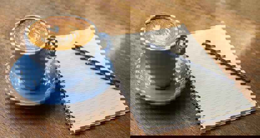 Kaffekopp med papper och penna.