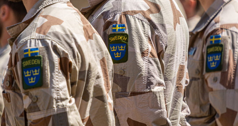 Tre personer i uniformsjackor. Foto.