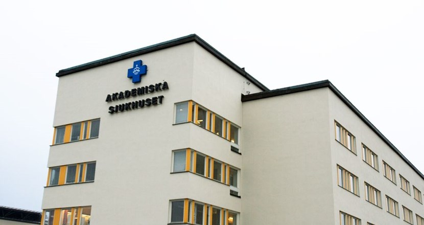 Bild en sjukhusbyggnad med Akademiska sjukhusets logotype. Foto.