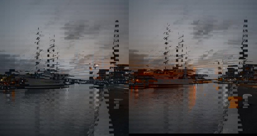 Kvällsbild från Åbo hamn med ett segelfartyg i fokus. Foto.