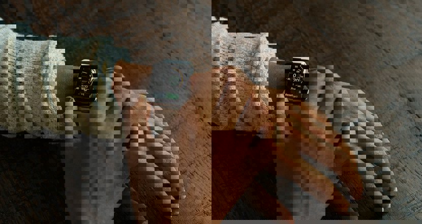 En hand som fixar med en smart klocka på andra armen. Foro.