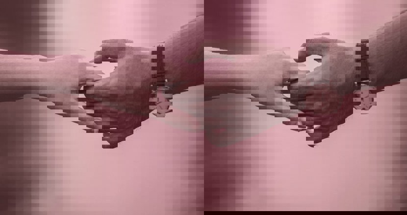 En kvinnas och en mans händer om håller löst i varandra.