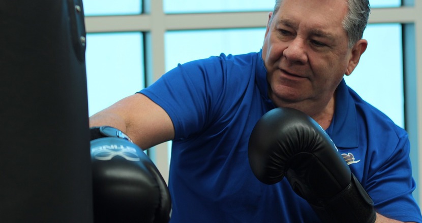 Boxning används som parkinsonrehabilitering. En man med boxningshandskar som slår ett slag. Bild: pixabay.com.