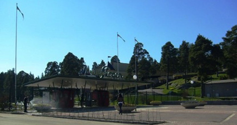 Våravslutning i Mariebergsskogen - entrén till Mariebergsskogen mot en klarblå himmel. Foto.