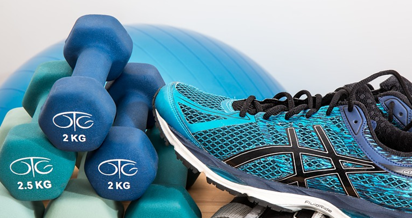 Blå träningsprylar - hantlar, balansboll och träningsskor. Foto.