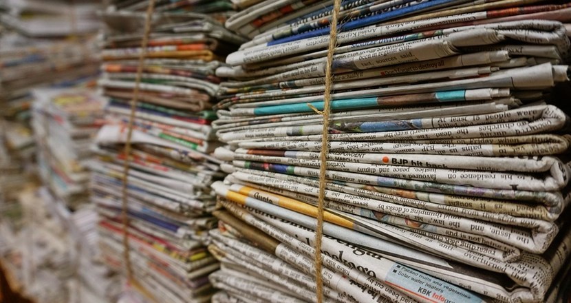 Staplade buntar med dagstidningar. Fotografi. 