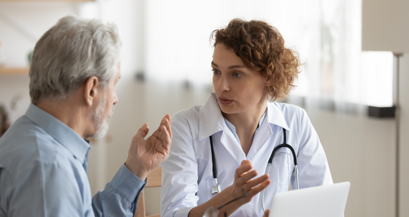 En äldre man som samtalar med en läkare. Foto.