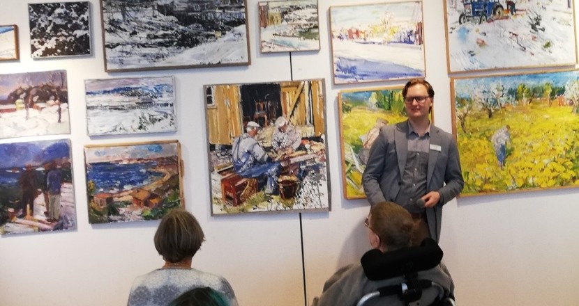 Medlems-nytt nr 3/2021 - en bild på en grupp som sitter framför en guide på  Lars Lerins konsthall Sandgrund. Foto.