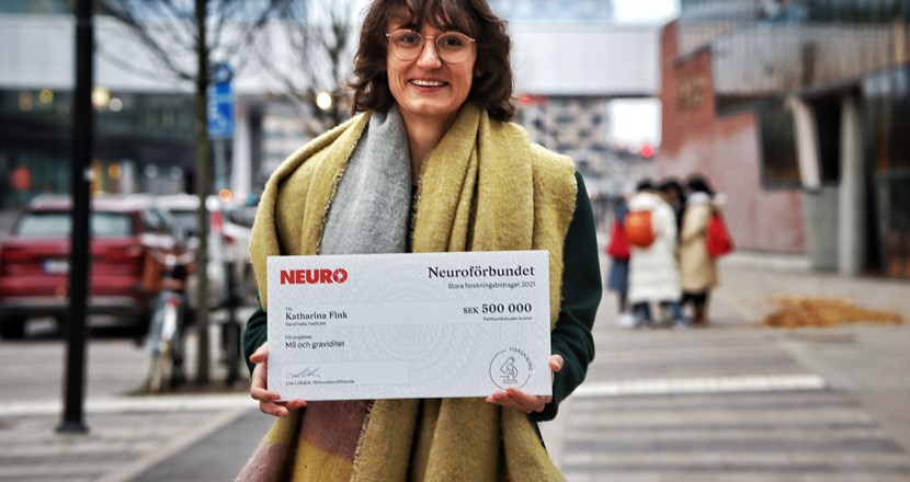 Katharina Fink håller i en stor check på 500 000 kronor. Foto.