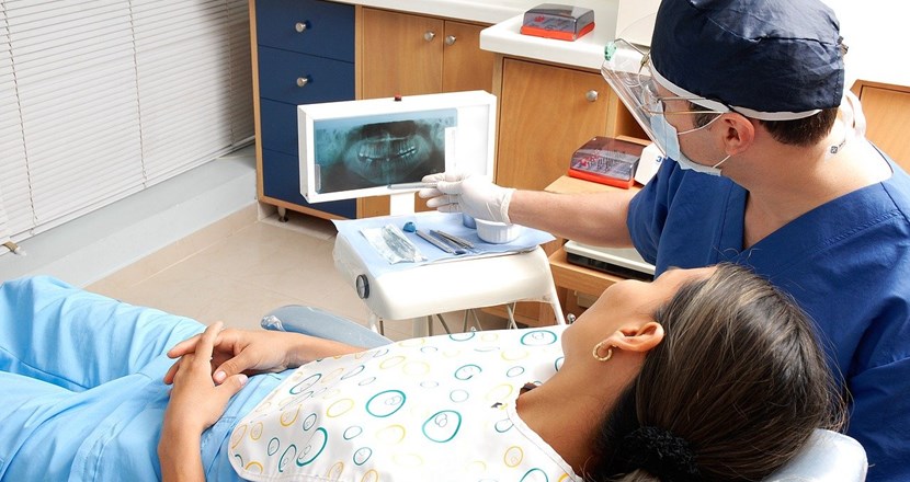 En patient och en tandläkare som tittar på en röntgenbild. Foto.