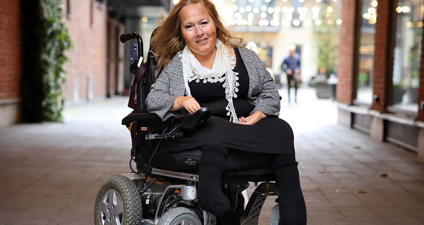 Maria Liljeroth i sin rullstol utomhus. Foto.