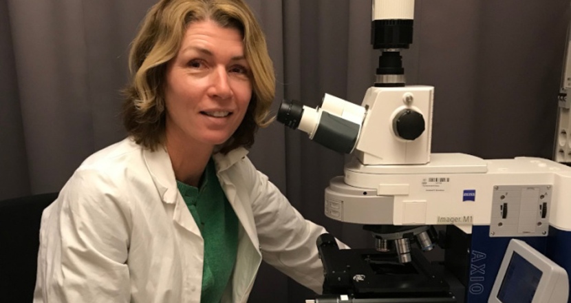 Eva Hedlund vide ett mikroskop. Foto.