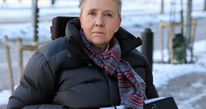 Lise Lidbäck allvarlig på en snöig trottoar. Foto.