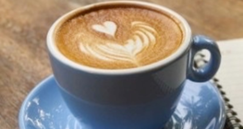 En kopp kaffe i ljusblått porslin på en mörkbrun bordsskiva. Foto. pixabay.com.