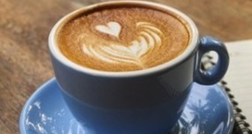 En kopp kaffe i ljusblått porslin på en mörkbrun bordsskiva. Foto. pixabay.com.