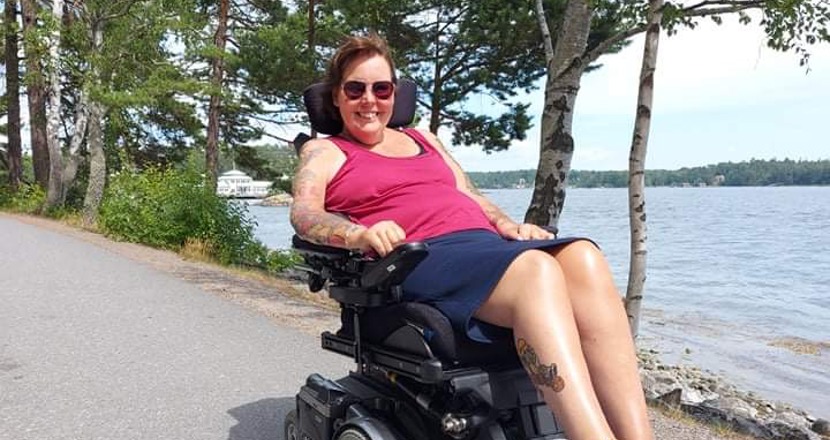 Mia Möllberg i sin rullstol i solen. Foto.