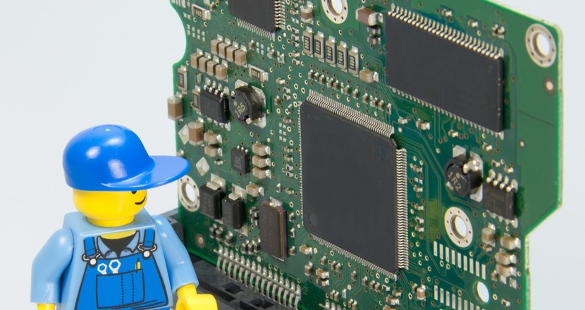 En legogubbe, en hantverkare som tittar på ett kretskort. Bild: Pixabay.