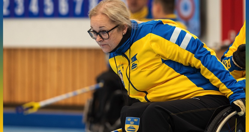 Rullstolscurlingspelaren Sabina Johansson i landslagsdress. En kvinna i rullstol i gul-blå dress. Bild.