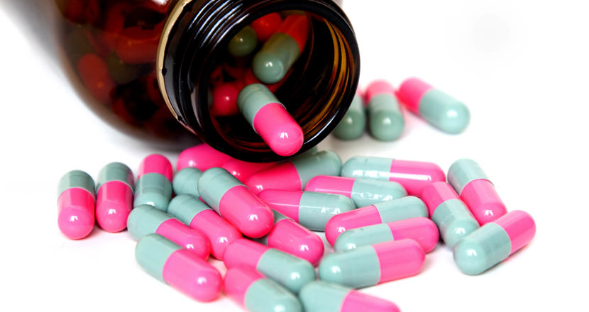 Liggande pillerburk med utspridda piller.