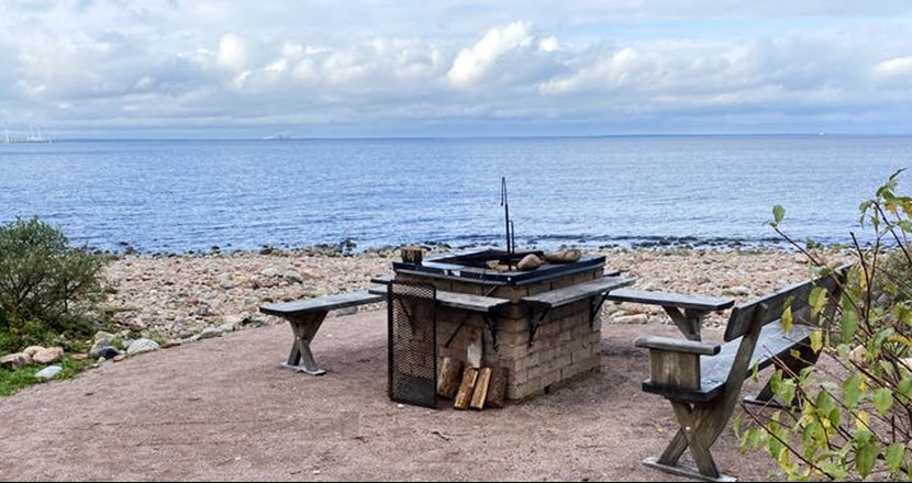 En tillgänglig grillplats vid stranden med utsikt över havet och horisonten. Foto, sommartid.