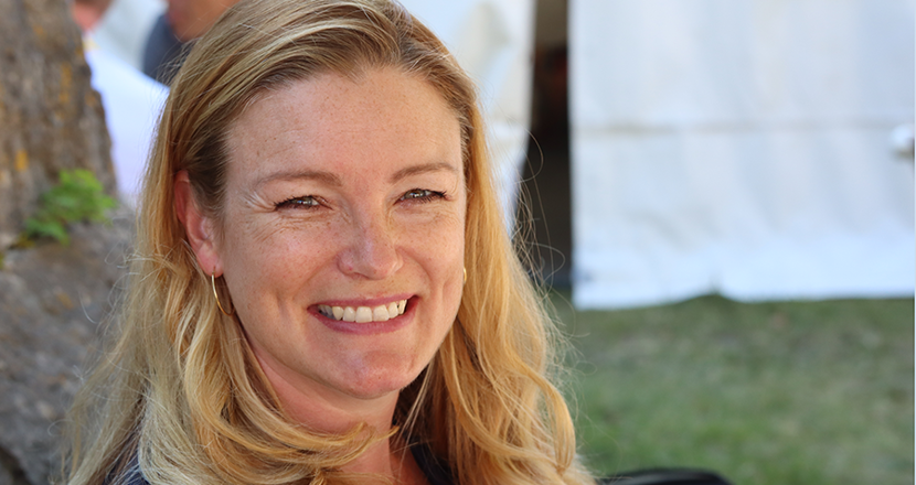 Porträttbild på Anna Cunningham med ett vitt tält i bakgrunden. Foto.