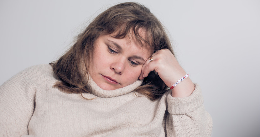 En person som vilar lutad mot ena handen. Foto.