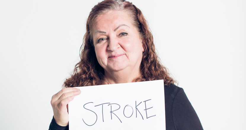 Kvinna som håller upp en skylt med texten 