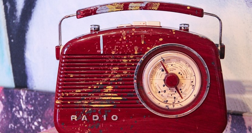 En röd gammal bärbar radioapparat. Foto.