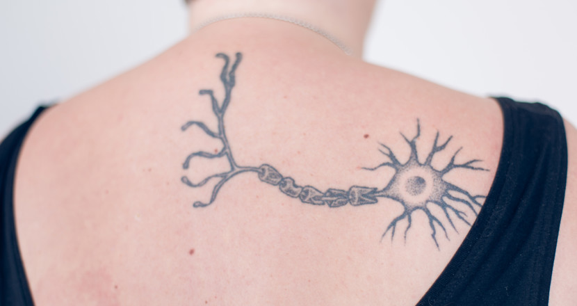 Ett neuron tatuerat på ryggen på en kvinna. Foto.