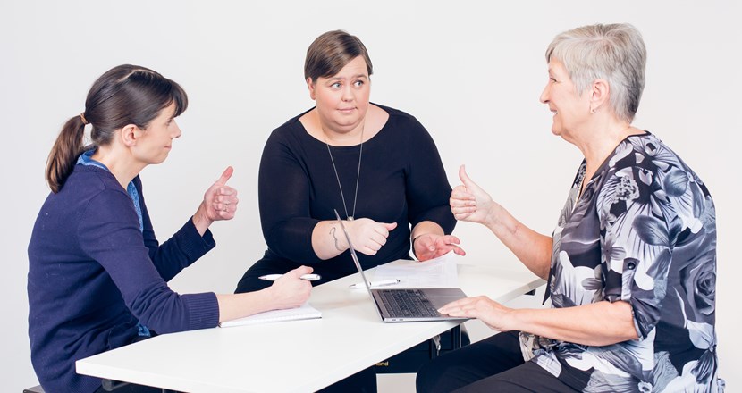 Tre kvinnor i möte runt ett bord. Foto.