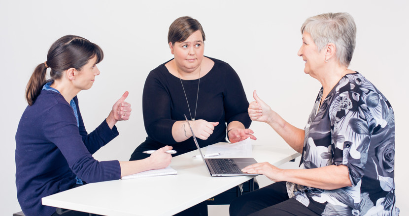 Tre kvinnor i möte runt ett bord. Foto.