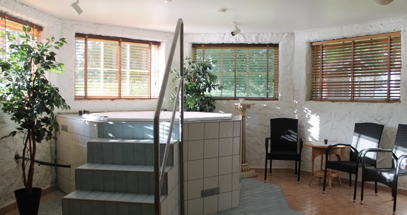 En liten bubbelpool med en kakelklädd trapp upp dit. Foto.