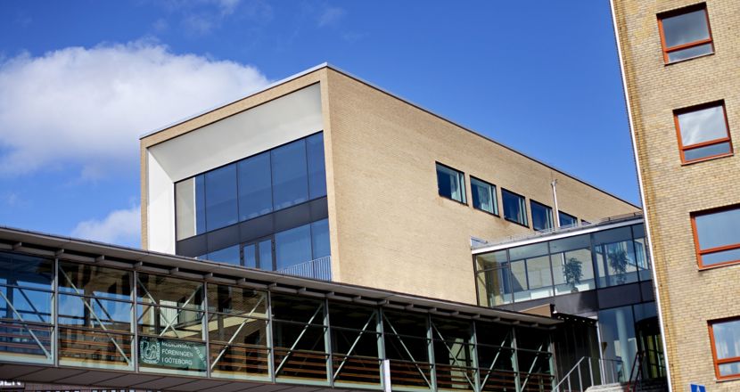 Bild på en byggnad och en inglasad gång. Foto.