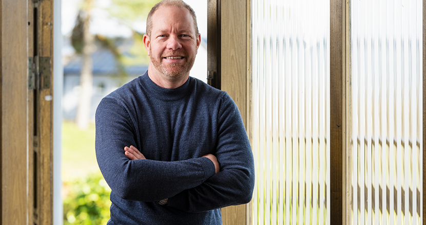 Mattias framför en glasvägg. Foto.