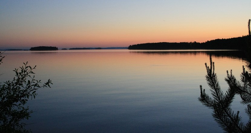 Solnedgång över en sjö. Foto.