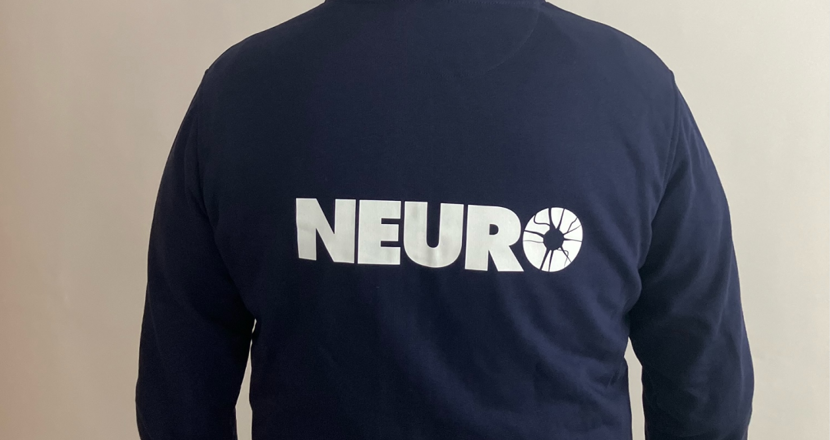 Person iklädd blå hoodie fotograferad bakifrån med luvan uppe.